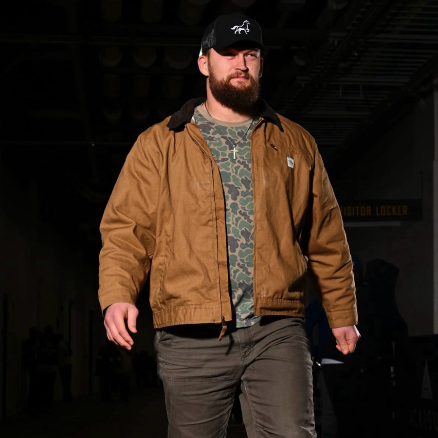 A black Stally horse cap worn with a tan work jacket