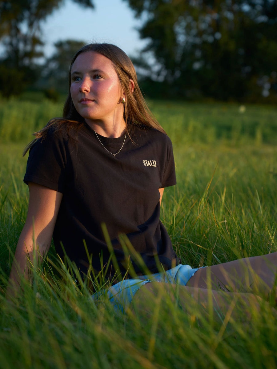 A charcoal Stally tee worn in the afternoon sun