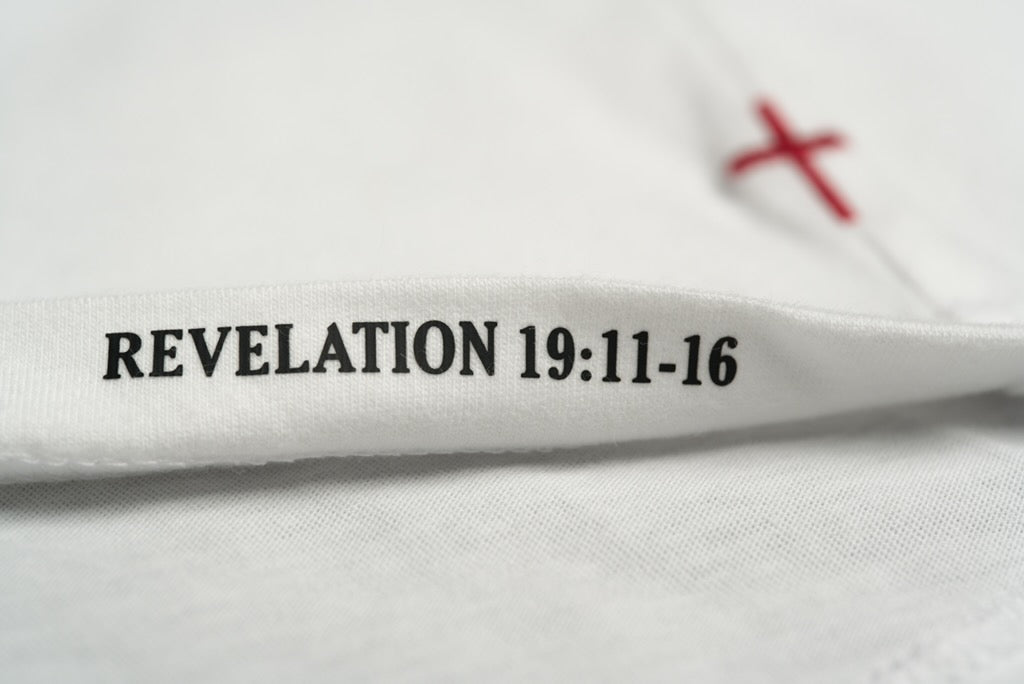 REVELATION 19:11–16 printed inside a chalk Stally tee, with red cross stitching behind