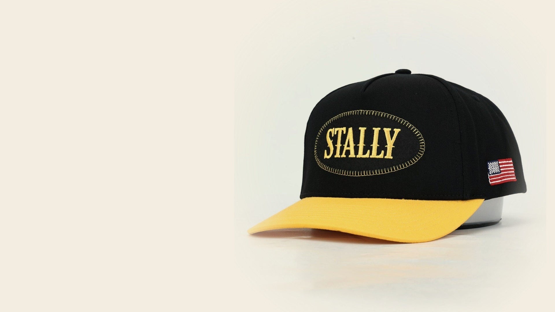 The Black & Gold Stally cap: black crown, gold bill, gold STALLY lettering on a black oval patch, an American flag on the side