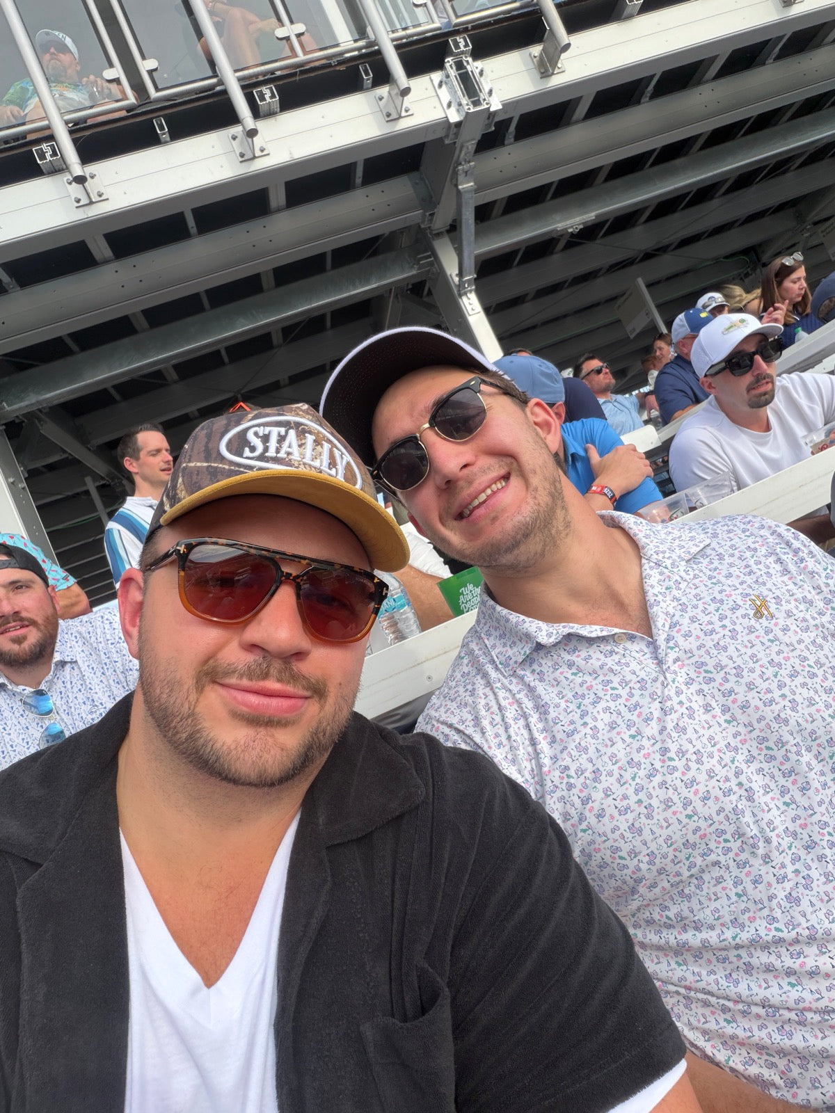 Man in a stadium wearing Camo STALLY Hat at Waste Management.