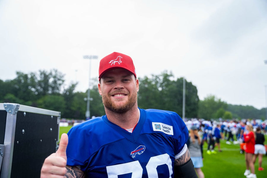 A football player wearing a red Stally horse cap on the field.
