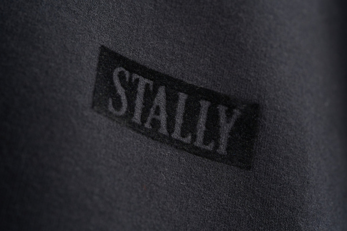 Horsepower Mens Boxy Tee in Coal Black, tonal flocked STALLY wordmark at the chest, close-up