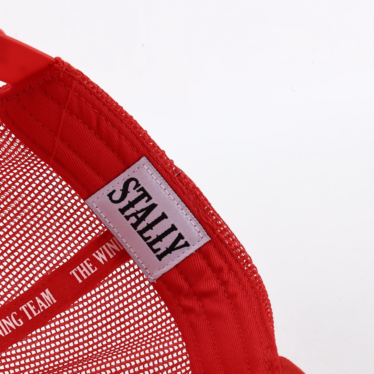 Red cap with a 'STALLY' label on a white background