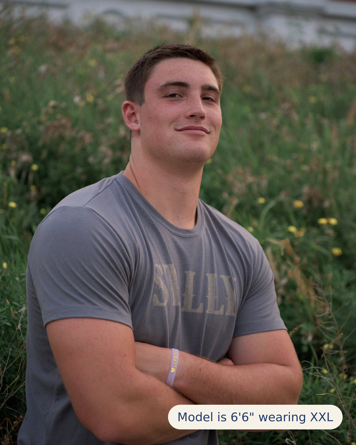 Stally Workhorse Performance Tee in Iron worn in a field, arms crossed