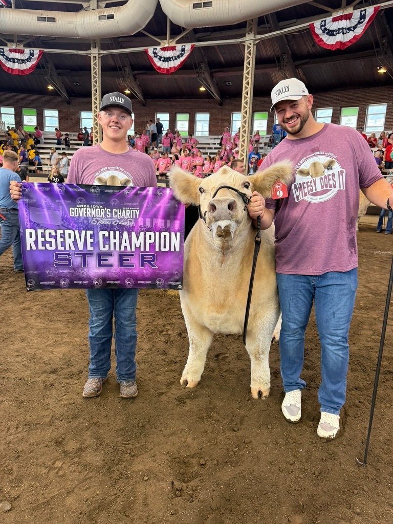Ike and a young exhibitor with their steer and the 2026 Iowa Governor's Charity Steer Show Reserve Champion Steer banner
