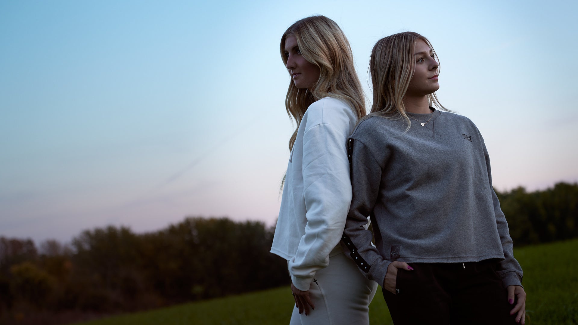 Two women back to back at dusk in Chalk White and Grey Heather Stally Range women's boxy crews
